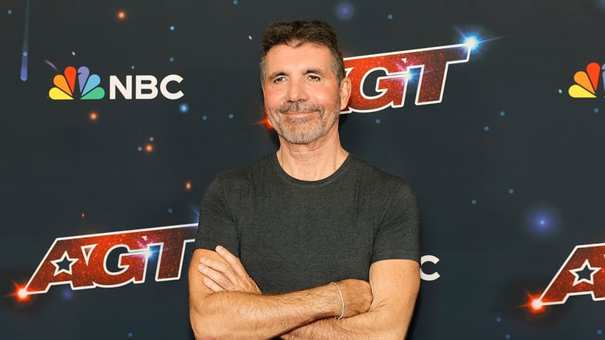 Simon Cowell standing with arms crossed