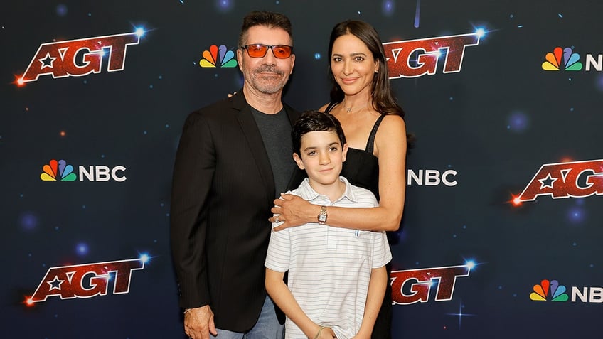 Simon Cowell, Lauren Silverman, and their son Eric posing together