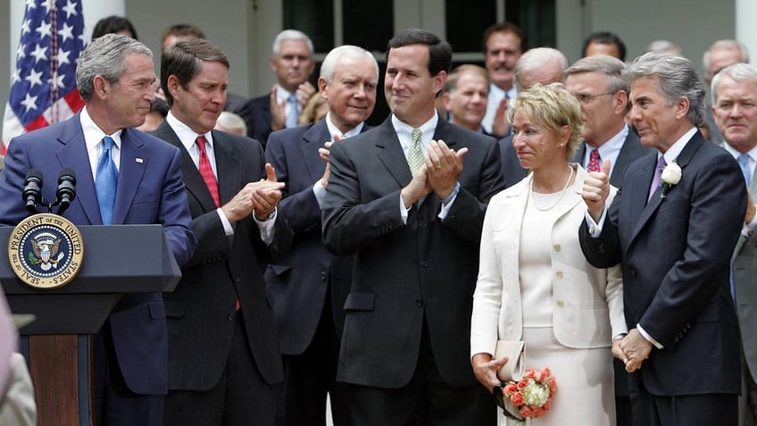 President George W. Bush looking at John Walsh as he gives him a thumbs up