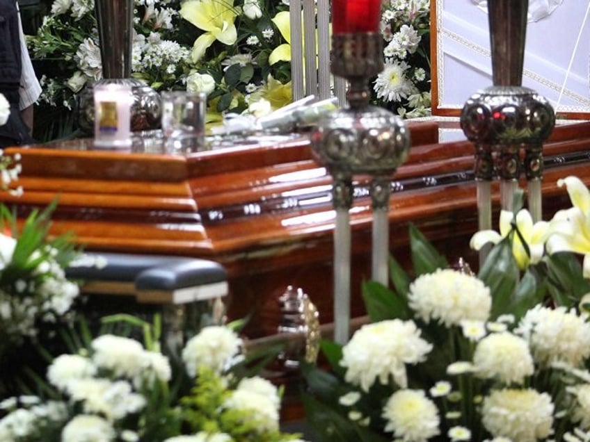 A mourner stands next to the coffin containing the remains of slain journalist Victor Manu