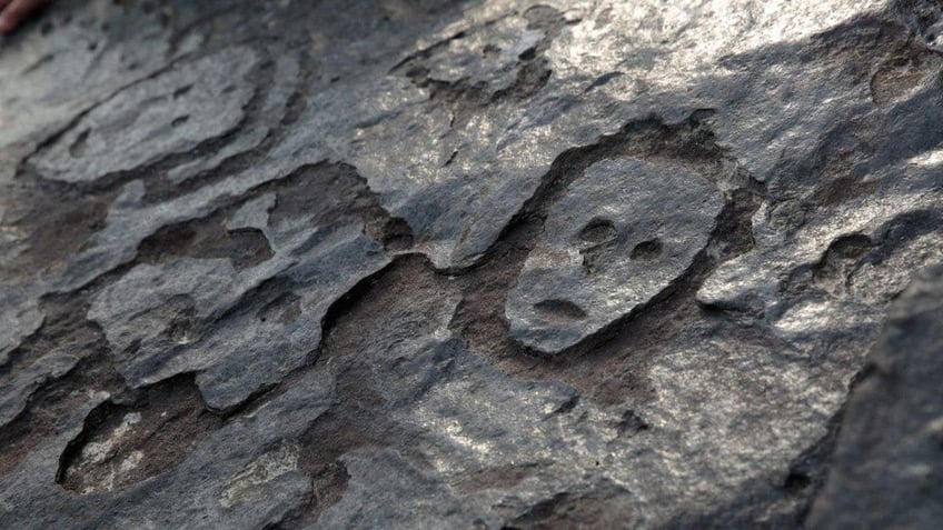 ancient brazilian rock carvings of human faces revealed along amazon river