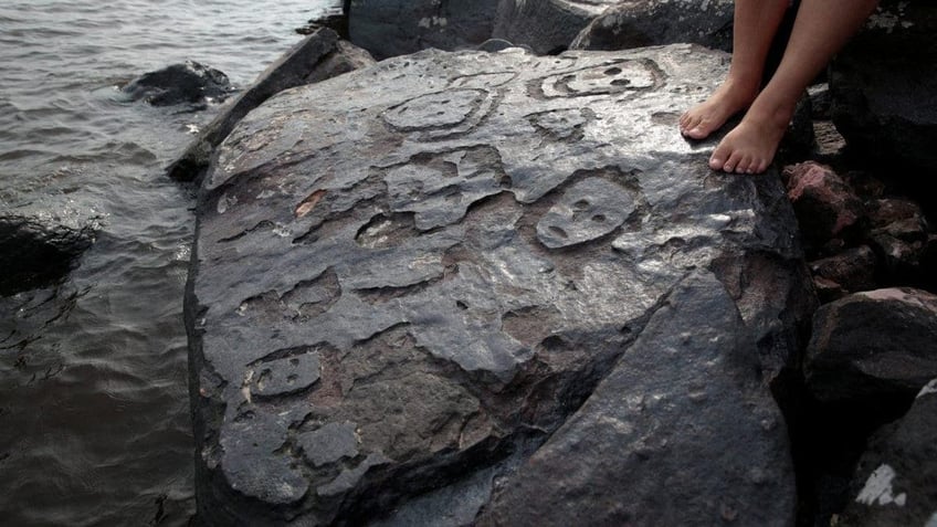 ancient brazilian rock carvings of human faces revealed along amazon river