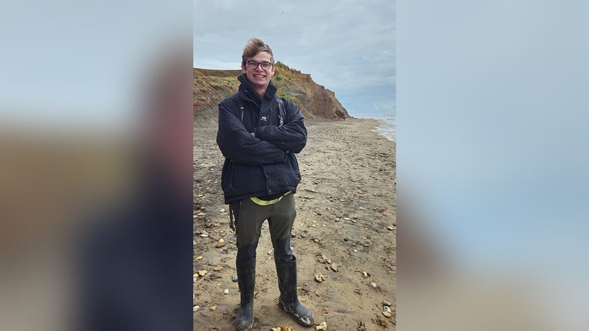 Paleontologist Joe Thompson stands on a beach in the Isle of Wight, the very location where he found the dinosaur footprint.