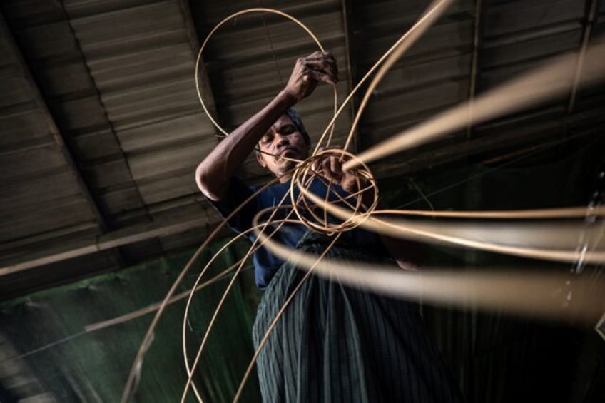 A man weaves cane into a traditional Myanmar chinlone ball at a workshop in Hinthada towns