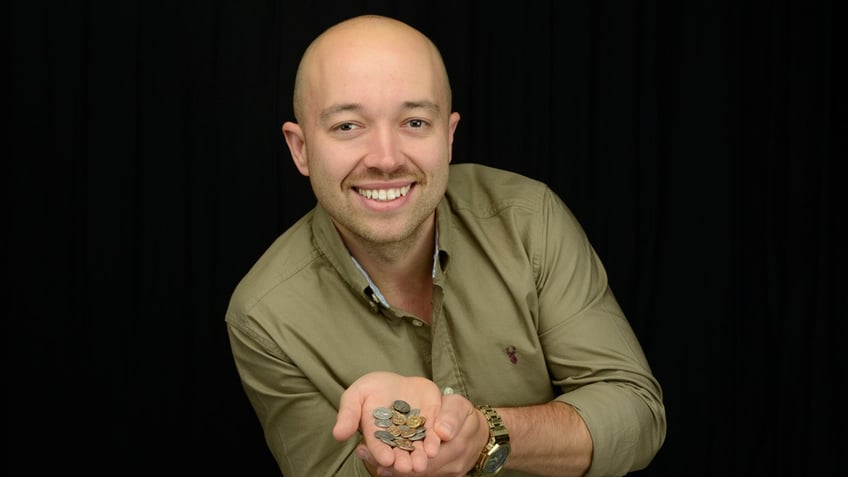 George Ridgway holding coins that he found