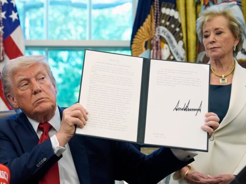 FILE - President Donald Trump holds a signed an executive order relating to school discipl