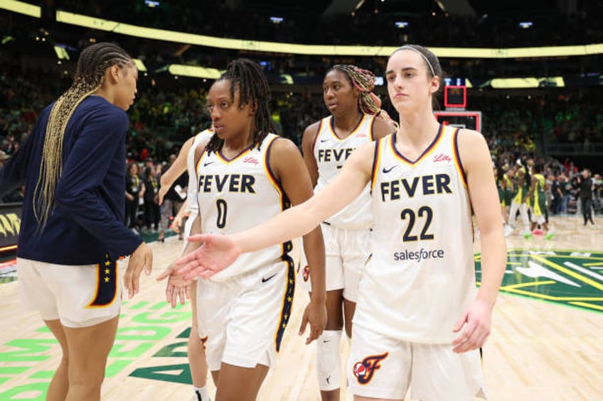 Caitlin Clark of the Indiana Fever shakes hands with teammates after losing to the Seattle Storm 85-83 in the gme at Climate Pledge Arena on May 22,...