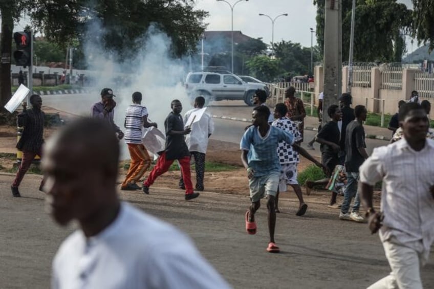 Protesters run for safety after Nigerian police fire tear gas at demonstrators