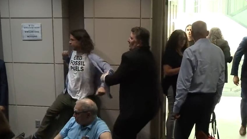 angry climate change protestors force commerce secretary gina raimondo to flee talk at the wilson center