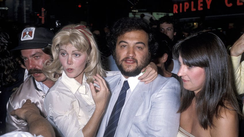 John Belushi being embraced by several cast mates.