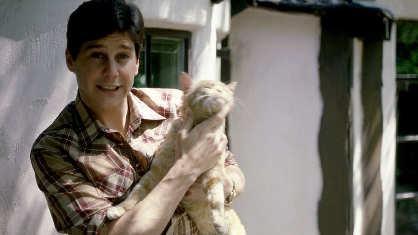 Tim Matheson holding a cat.