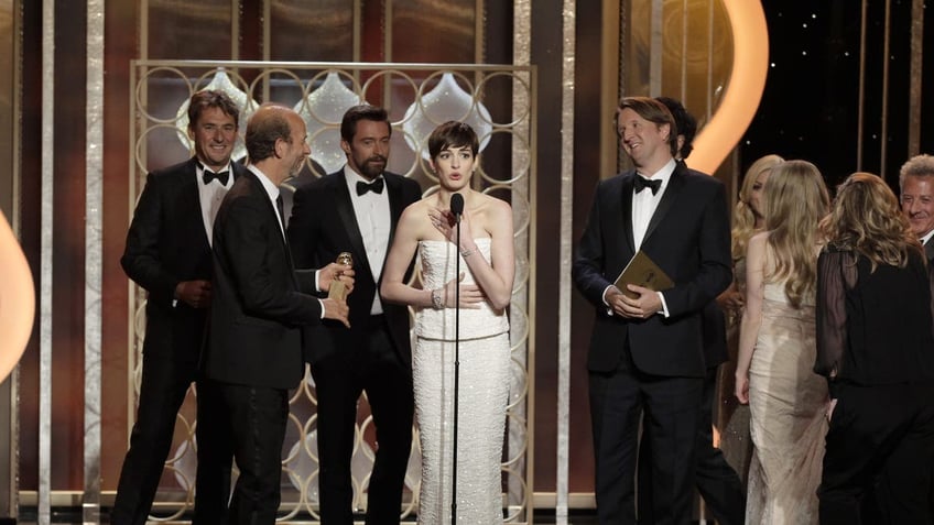 anne hathaway with cast and producers of les mis on stage at the golden globes