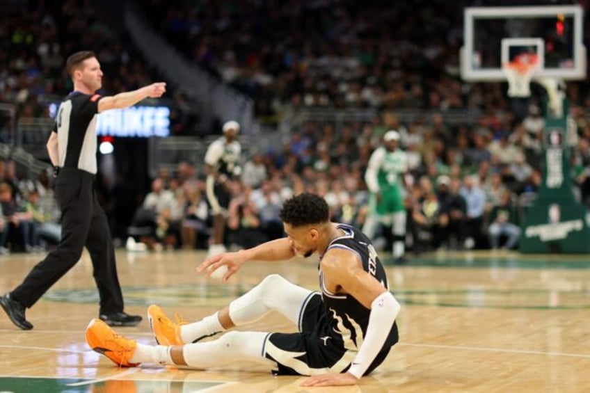 Down and out: Milwaukee star Giannis Antetokounmpo tumbles to the floor after suffering a