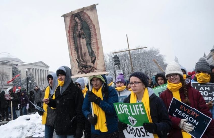 Anti-abortion demonstrators trudge through slushy streets in Washington on January 19, 2024 during the annual 'March for Life'