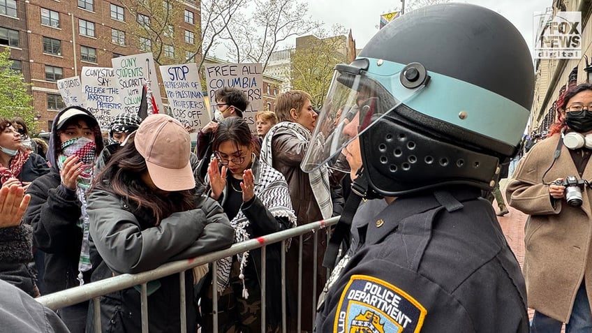 NYPD officers patrol as pro-Palestine protesters demonstrate outside of Columbia University’s campus