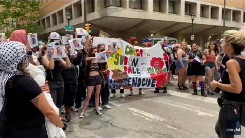 anti-israel marchers holding pro-palestinian sign