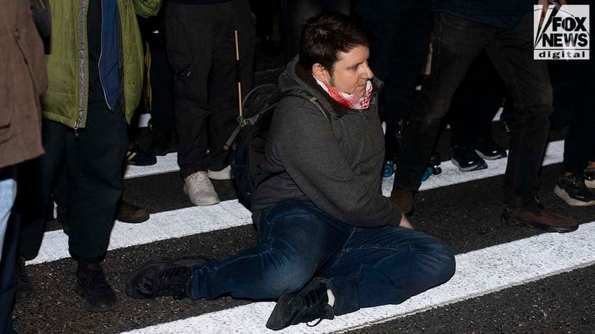Man sits on street corner during protest