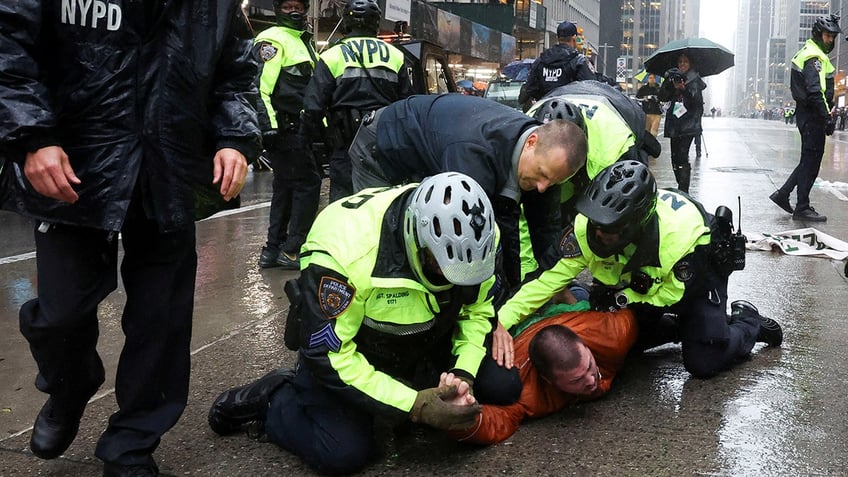 Police officers detain a protester