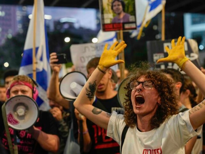 A demonstrator with her hands painted in yellow calls for a cease-fire deal and the immedi