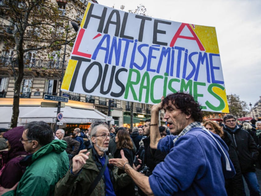 PARIS, FRANCE - 2023/11/12: A protester holds a placard that says "Stop the antisemitism and all the racism" at the end of the demonstration against antisemitism. Demonstrations against antisemitism took place all over France. In Paris, close to 105 thousand people were present at the civic march against anti-Semitism organized …