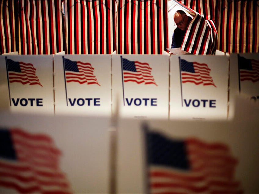 FILE - Jim Smith steps out of a voting booth after marking his ballot at a polling site fo