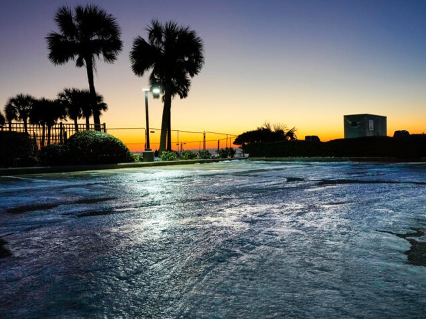 Ice and snow remain on the ground as the sun rises over the Gulf of Mexico in the aftermat