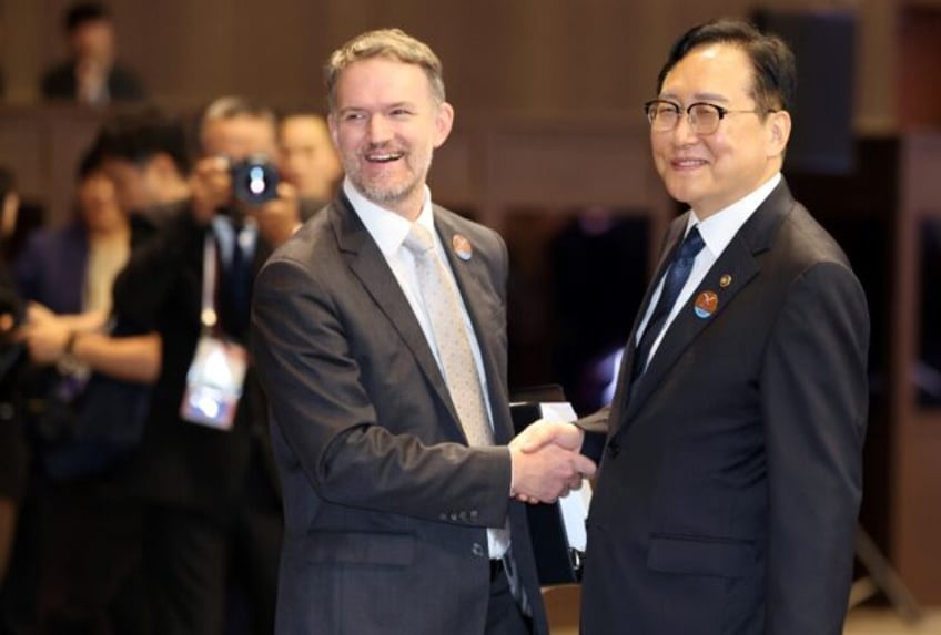 South Korean Trade Minister Cheong In-kyo (right) shakes hands with US trade representativ