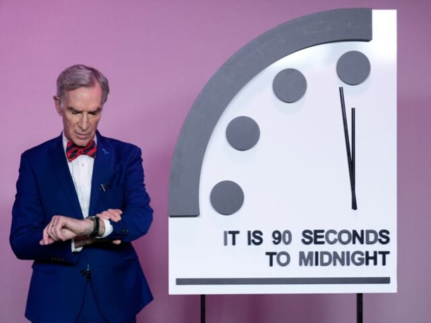 Science educator Bill Nye, looks at his watch next to the "Doomsday Clock," shortly before the Bulletin of the Atomic Scientists announces the latest decision on the "Doomsday Clock" minute hand, Tuesday, Jan. 23, 2024, at the National Press Club Broadcast Center, in Washington. This year, Jan. 2024, the clock …