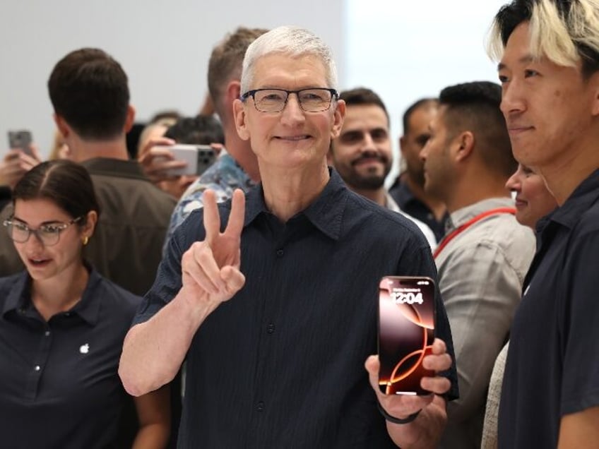 Apple boss Tim Cook holding an iPhone