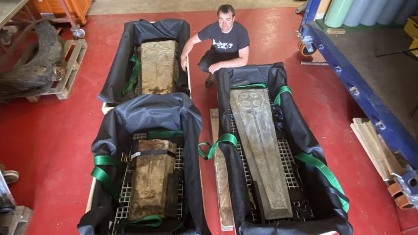 Man standing next to ancient slabs