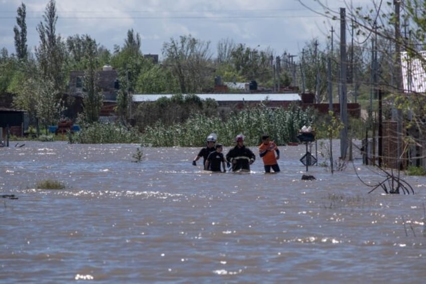 Rescuers wade through floodwaters following a heavy storm that hit the Argentinian port ci