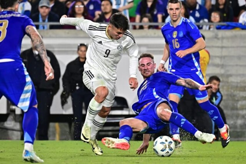 Argentina midfielder Alexis Mac Allister slides in to tackle Costa Rica forward Manfred Ug