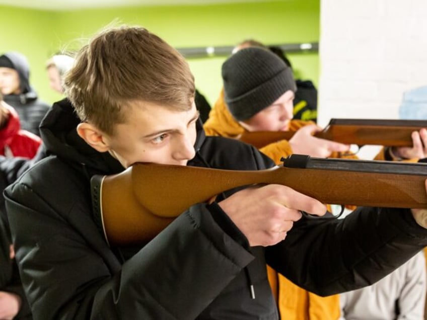 NEMISHAIEVE, KYIV OBLAST, UKRAINE - 2023/02/20: School boys learn to shoot a weapon as the