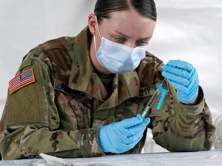 U.S. Army medic Kristen Rogers of Waxhaw, N.C. fills syringes with the Johnson & Johns