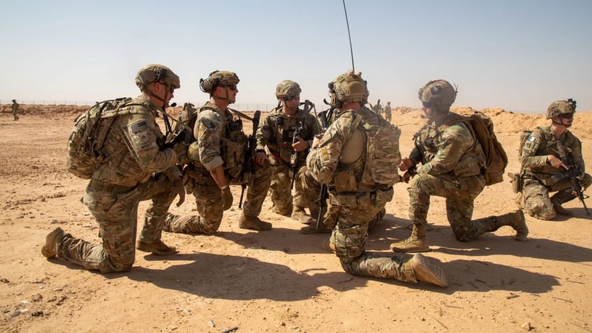 soldiers kneeling at Al-Asad air base