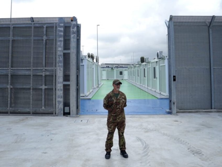 An Italian police officer stands in a recently build Italian-run migrant centre at the por