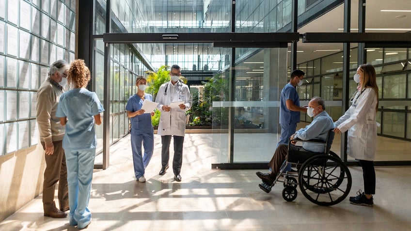 people and doctors walking around a hospital