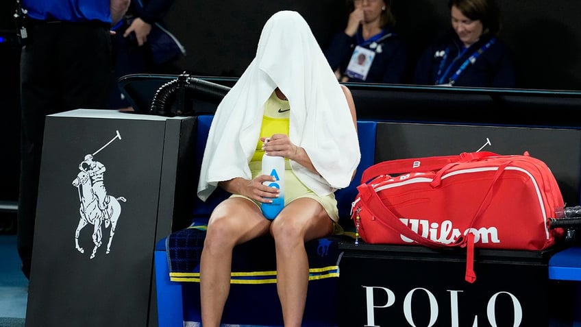 Aryna Sabalenka with towel over head