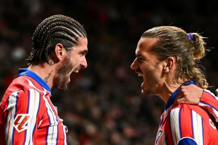 Atletico Madrid's Argentine midfielder Rodrigo De Paul (L) celebrates scoring with Antoine