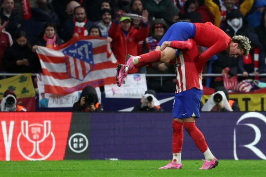 Atletico Madrid's French forward Antoine Griezmann is lifted by defender Jose Gimenez in celebration after his brilliant strike against Real Madrid