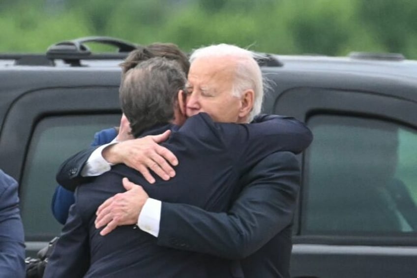 US President Joe Biden (R) hugs his son Hunter Biden upon arrival in Delaware after the yo