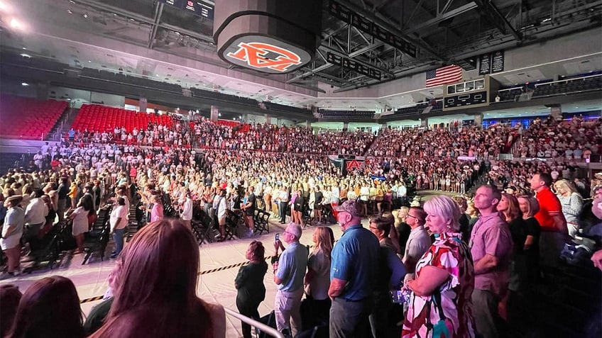 auburn students rush into lake for impromptu baptisms as football coach lends a hand at massive worship event