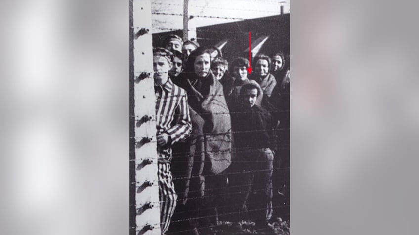 Ryszard Horowitz, highlighted, behind the barbed wire of Auschwitz Concentration Camp, Liberation of the camp in 1945. Photo courtesy Ryszard Horowitz.