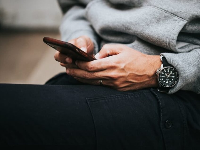 person in gray sweater wearing black and silver chronograph watch, unsplash