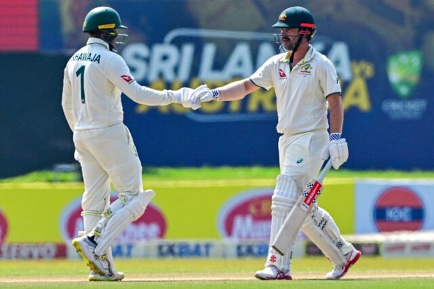 Australia's Usman Khawaja (left) and teammate Travis Head bump fists on the fourth day of