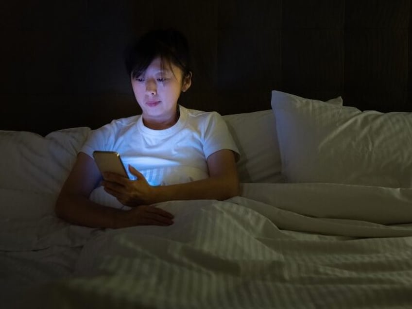 Woman using smartphone in bed