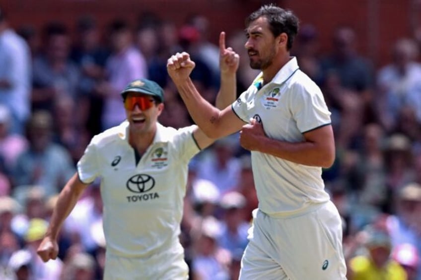 Australia's Mitchell Starc (R) and captain Pat Cummins celebrate another Indian wicket