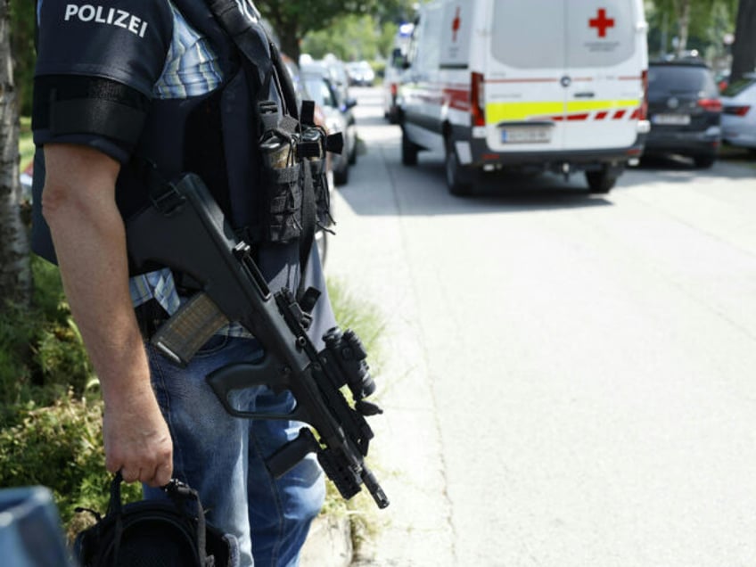 A policeman is seen next to an ambulance car close to a school where, according to reports