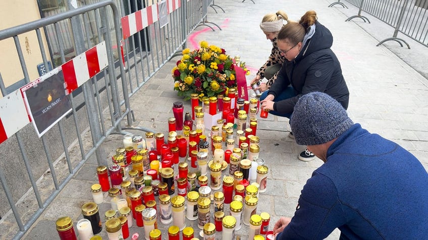 Candles places where a Syrian national killed a 14-year-old and stabbed others in Austria