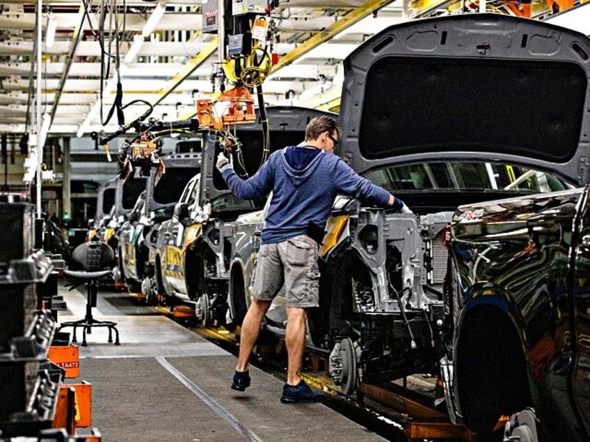 A worker installs an engine at the General Motors assembly plant in Fort Wayne, Indiana, U